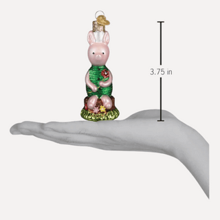 Decorative Piglet ornament with green outfit on a hand for scale, showing height of 3.75 inches.
