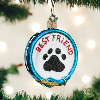 Christmas ornament with 'Best Friend' and paw print on a blue background, hanging on a tree.