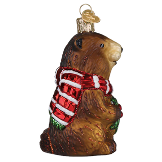 Glass ornament of a bear wearing a red scarf on a white background