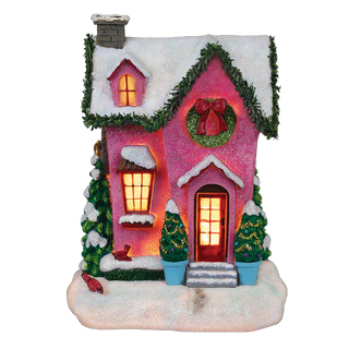 Decorative Christmas house with pink exterior, glowing windows, and festive decorations on a white background.