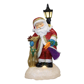 Decorative figure of Santa Claus with a reindeer under a street lamp on a white background